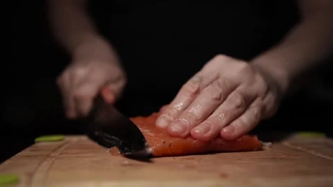 Close-Up of Hands Slicing Fresh Salmon Fillet on a Dark Background 스톡 동영상 291526692