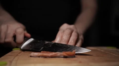 Close-Up of Hands Slicing Fresh Salmon Fillet on a Dark Background Stock Footage 291526701