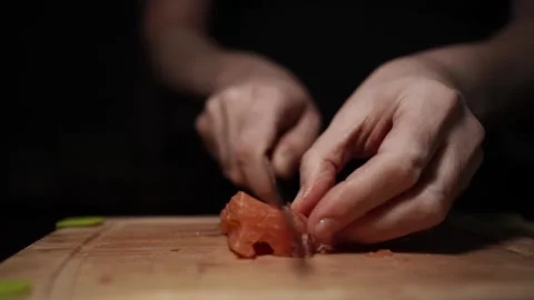 Close-Up of Hands Slicing Fresh Salmon Fillet on a Dark Background Stock-Footage 296232644