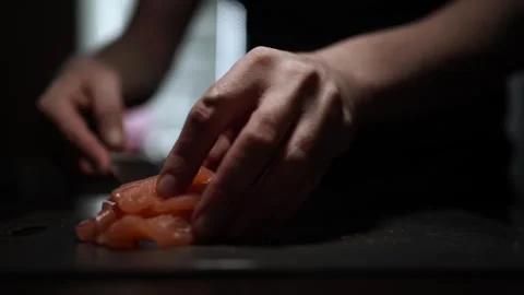 Close-Up of Hands Slicing Fresh Salmon Fillet on a Dark Background 스톡 동영상 296234417