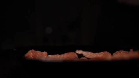 Close-Up of Hands Slicing Fresh Salmon Fillet on a Dark Background Video stock 296234438