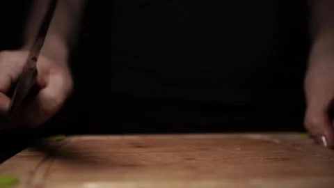 Close-Up of Hands Slicing Fresh Salmon Fillet on a Dark Background Stock Footage 296234440