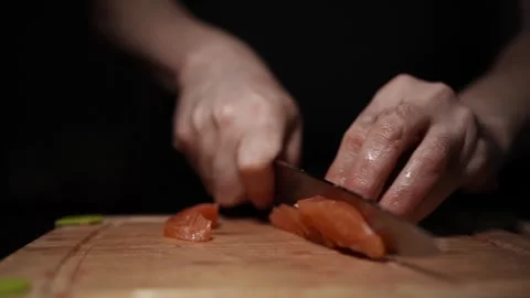 Close-Up of Hands Slicing Fresh Salmon Fillet on a Dark Background 스톡 동영상 296234445