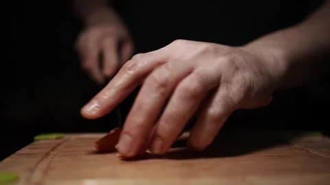 Close-Up of Hands Slicing Fresh Salmon Fillet on a Dark Background 스톡 동영상 296234447