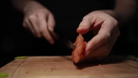 Close-Up of Hands Slicing Fresh Salmon Fillet on a Dark Background Stock Footage 296422008