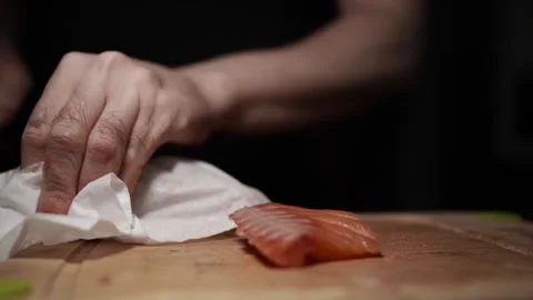 Close-Up of Hands Slicing Fresh Salmon Fillet on a Dark Background 스톡 동영상 296422009