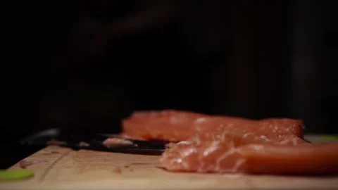 Close-Up of Hands Slicing Fresh Salmon Fillet on a Dark Background 스톡 동영상 296422079