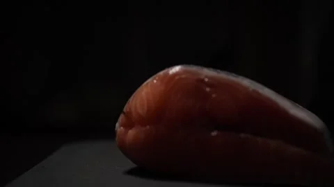 Close-Up of Hands Slicing Fresh Salmon Fillet on a Dark Background 스톡 동영상 296423049