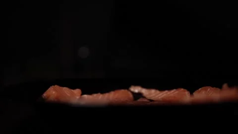 Close-Up of Hands Slicing Fresh Salmon Fillet on a Dark Background 스톡 동영상 296424434