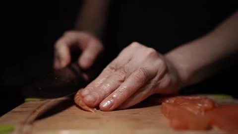 Close-Up of Hands Slicing Fresh Salmon Fillet on a Dark Background 스톡 동영상 296424808