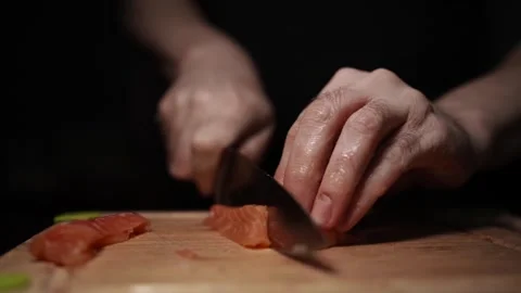 Close-Up of Hands Slicing Fresh Salmon Fillet on a Dark Background Stock-Footage 296424909