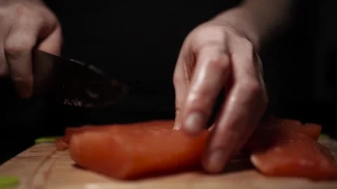 Close-Up of Hands Slicing Fresh Salmon Fillet on a Dark Background Stock-Footage 296425641