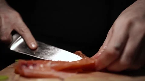 Close-Up of Hands Slicing Fresh Salmon Fillet on a Dark Background 스톡 동영상 296425786