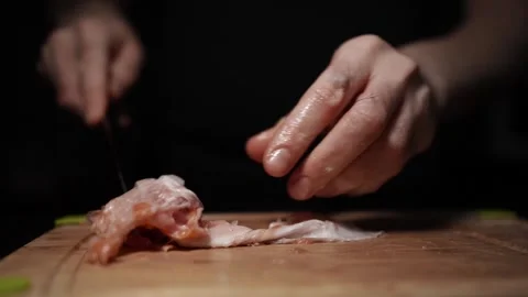 Close-Up of Hands Slicing Fresh Salmon Fillet on a Dark Background Stock Footage 296426116