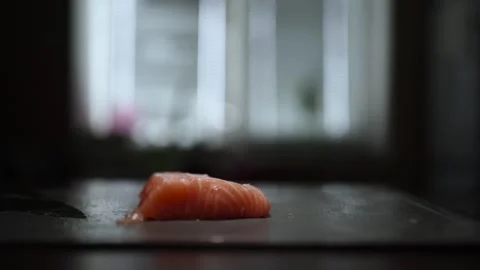 Close-Up of Hands Slicing Fresh Salmon Fillet on a Dark Background Stock Footage 296426810