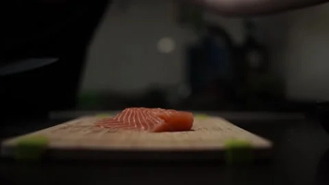 Close-Up of Hands Slicing Fresh Salmon Fillet on a Dark Background 스톡 동영상 296427705