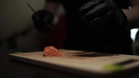 Close-Up of Hands Slicing Fresh Salmon Fillet on a Dark Background 스톡 동영상 296428168