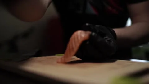 Close-Up of Hands Slicing Fresh Salmon Fillet on a Dark Background 스톡 동영상 296428169