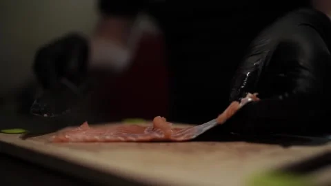 Close-Up of Hands Slicing Fresh Salmon Fillet on a Dark Background Stock Footage 296428463