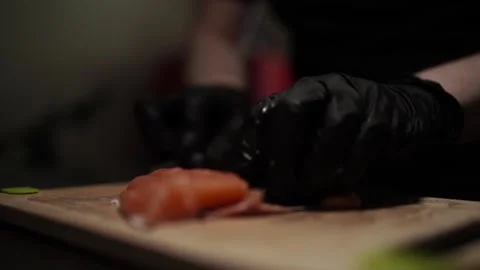 Close-Up of Hands Slicing Fresh Salmon Fillet on a Dark Background Stock-Footage 296428485