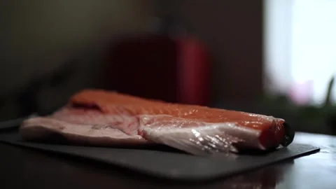 Close-Up of Hands Slicing Fresh Salmon Fillet on a Dark Background 스톡 동영상 296428502