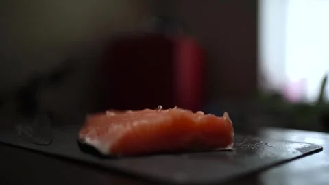 Close-Up of Hands Slicing Fresh Salmon Fillet on a Dark Background Stock-Footage 296428510