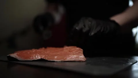 Close-Up of Hands Slicing Fresh Salmon Fillet on a Dark Background 스톡 동영상 296428529