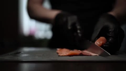 Close-Up of Hands Slicing Fresh Salmon Fillet on a Dark Background Stock-Footage 296428534