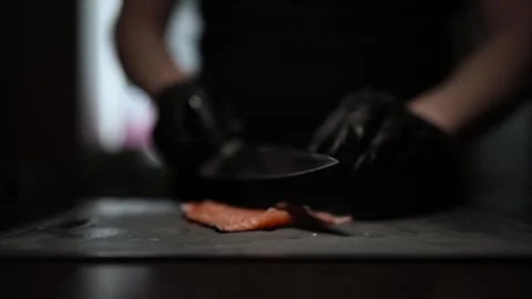 Close-Up of Hands Slicing Fresh Salmon Fillet on a Dark Background Vídeo Stock 303892001