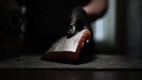 Close-Up of Hands Slicing Fresh Salmon Fillet on a Dark Background Stock Footage 303892008