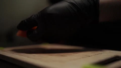 Close-Up of Hands Slicing Fresh Salmon Fillet on a Dark Background Video stock 303893777