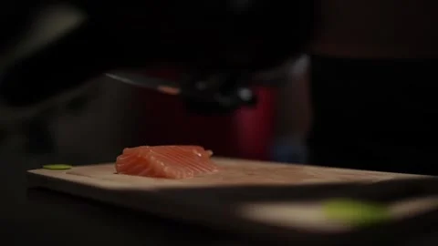 Close-Up of Hands Slicing Fresh Salmon Fillet on a Dark Background Stock-Footage 303893779