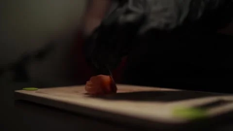 Close-Up of Hands Slicing Fresh Salmon Fillet on a Dark Background 스톡 동영상 303893789