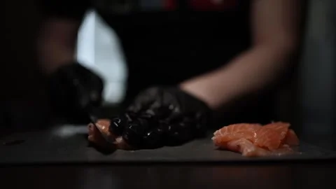 Close-Up of Hands Slicing Fresh Salmon Fillet on a Dark Background Video stock 303893885