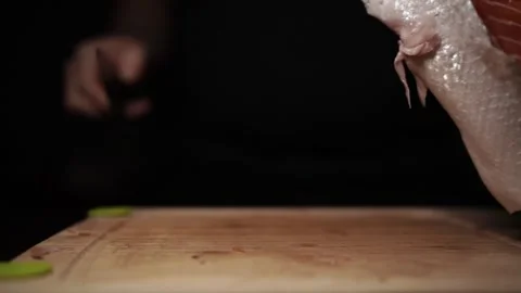 Close-Up of Hands Slicing Fresh Salmon Fillet on a Dark Background Video stock 303895403