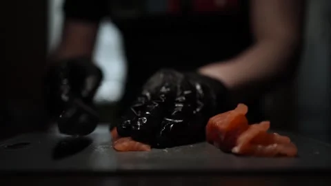 Close-Up of Hands Slicing Fresh Salmon Fillet on a Dark Background 스톡 동영상 303896959