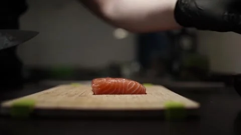 Close-Up of Hands Slicing Fresh Salmon Fillet on a Dark Background 스톡 동영상 303897095