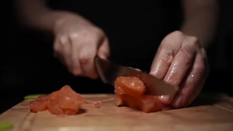 Close-Up of Hands Slicing Fresh Salmon Fillet on a Dark Background Vidéo 303898710