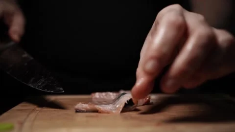 Close-Up of Hands Slicing Fresh Salmon Fillet on a Dark Background Vidéo 303900775