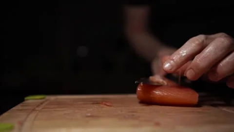 Close-Up of Hands Slicing Fresh Salmon Fillet on a Dark Background Stock-Footage 303900780
