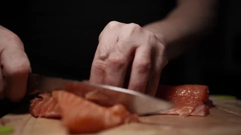 Close-Up of Hands Slicing Fresh Salmon Fillet on a Dark Background 스톡 동영상 303901077
