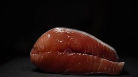 Close-Up of Hands Slicing Fresh Salmon Fillet on a Dark Background 스톡 동영상 303901592