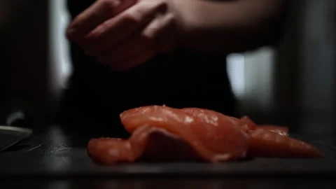 Close-Up of Hands Slicing Fresh Salmon Fillet on a Dark Background 스톡 동영상 303901598