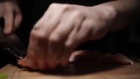 Close-Up of Hands Slicing Fresh Salmon Fillet on a Dark Background Video stock 303901646