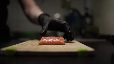 Close-Up of Hands Slicing Fresh Salmon Fillet on a Dark Background 스톡 동영상 303901648