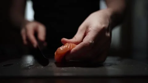 Close-Up of Hands Slicing Fresh Salmon Fillet on a Dark Background 스톡 동영상 303901981