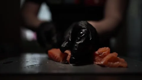 Close-Up of Hands Slicing Fresh Salmon Fillet on a Dark Background Stock-Footage 303901985