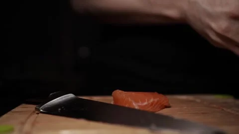Close-Up of Hands Slicing Fresh Salmon Fillet on a Dark Background Stock-Footage 303902007