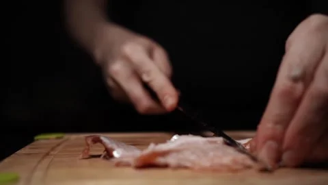 Close-Up of Hands Slicing Fresh Salmon Fillet on a Dark Background 스톡 동영상 303902409