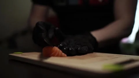 Close-Up of Hands Slicing Fresh Salmon Fillet on a Dark Background 스톡 동영상 303903609